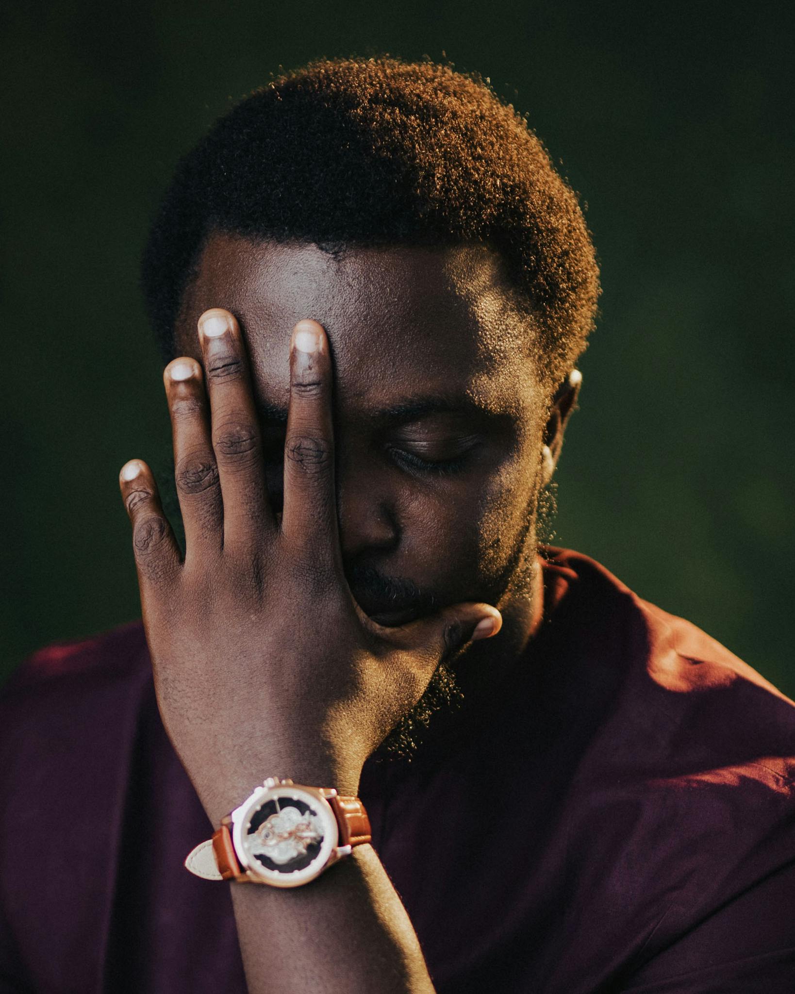 Moody portrait of a man contemplating with hand on face. Perfect for expressing introspection.